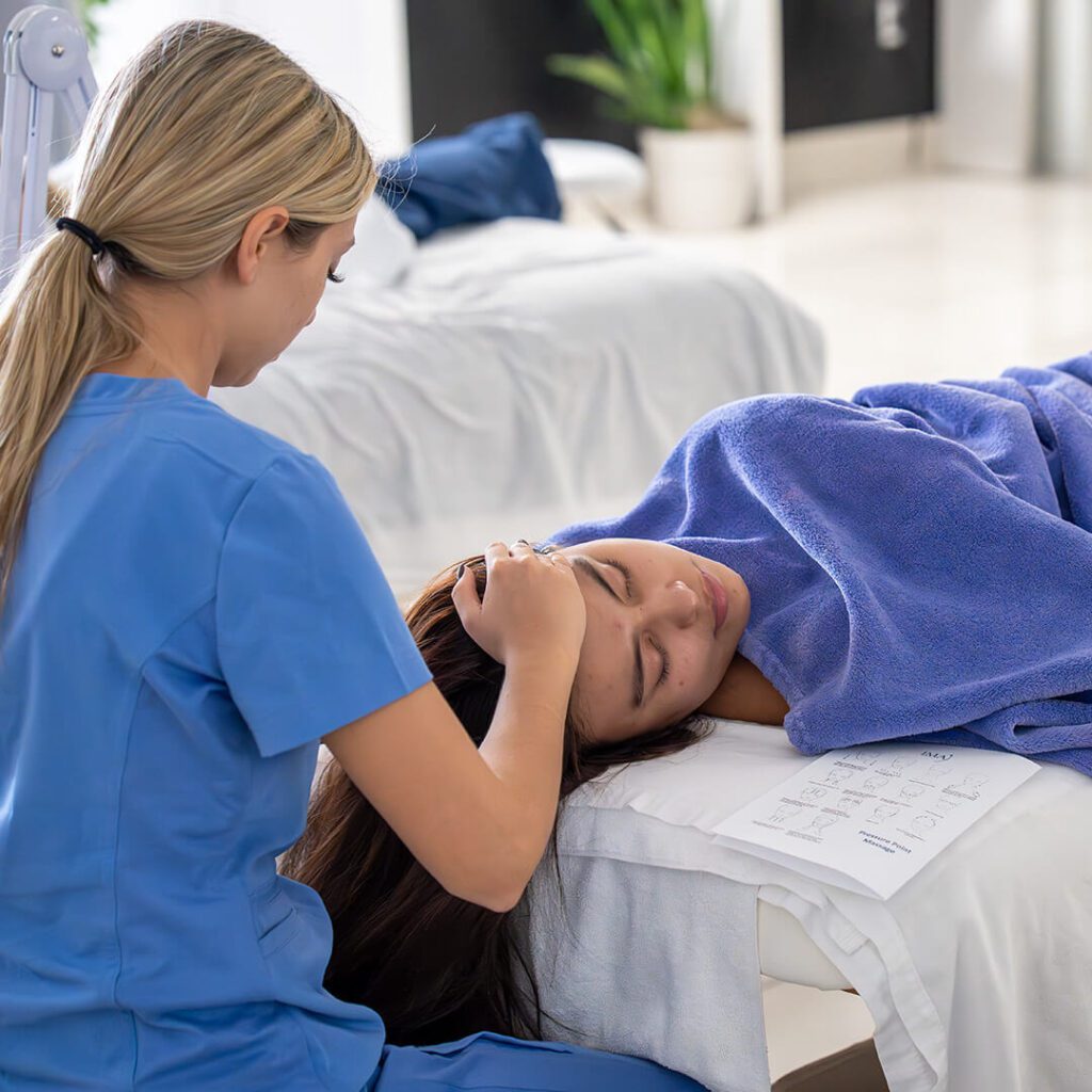 A client receiving a brightening facial treatment with specialized products at IMAj Institute.