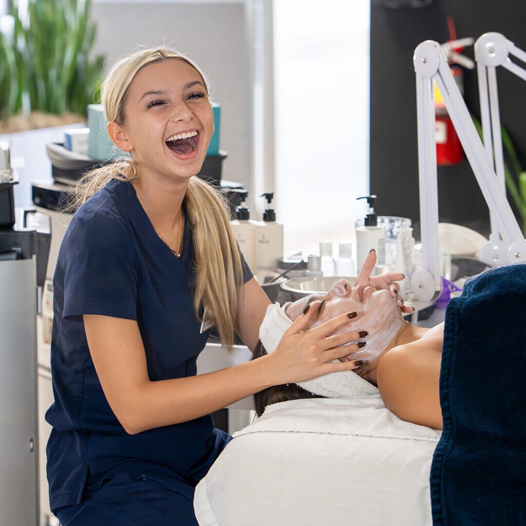 A relaxed client enjoying a facial treatment, illustrating the soothing environment at IMAj Institute.